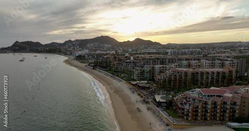 Sunrise Flight Over Cabo San Lucas Beach with City and Mountain Silhouettes
