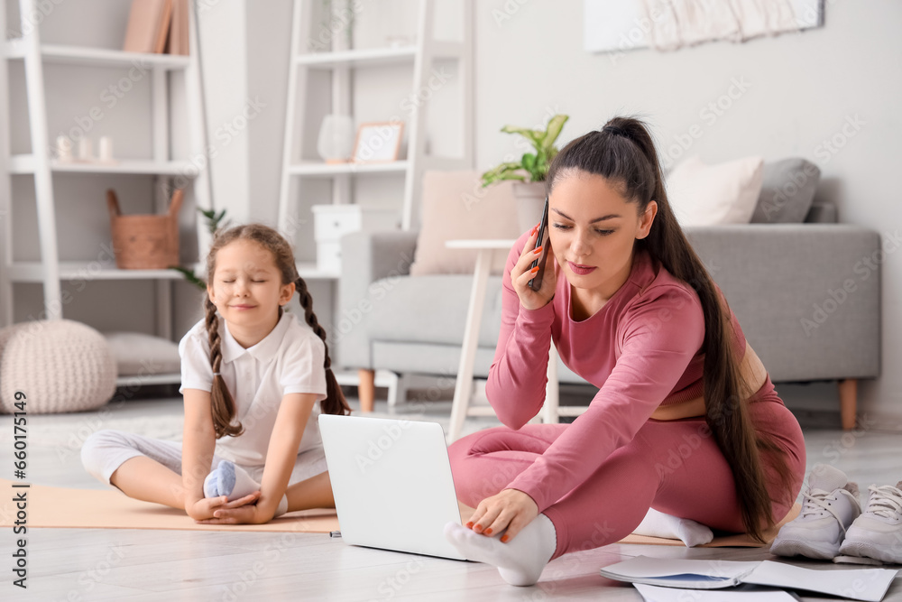 Working mother with her little daughter training at home Working mother with her little daughter training at home