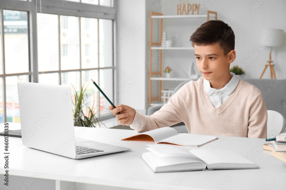 Little boy studying online with laptop at home Little boy studying online with laptop at home