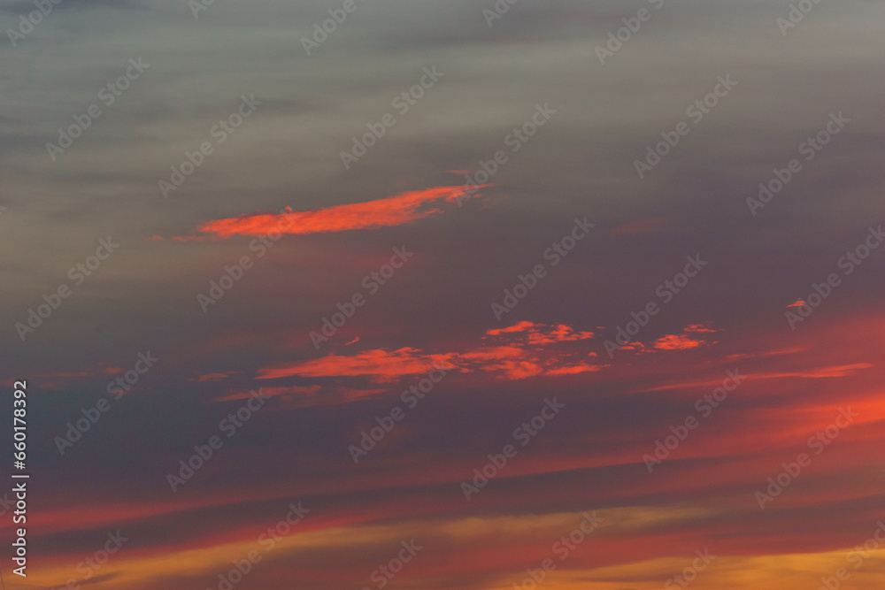 Orange red warm colorful clouds on the sky during sunset in the evening