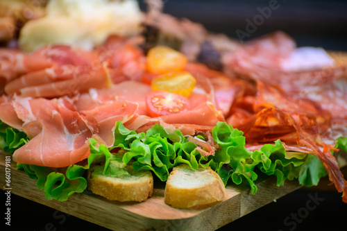 Fresh cuts of French cured sausages, ham, cheeses for party close up