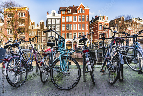Bicycles parked near a canal in Amsterdam city.
