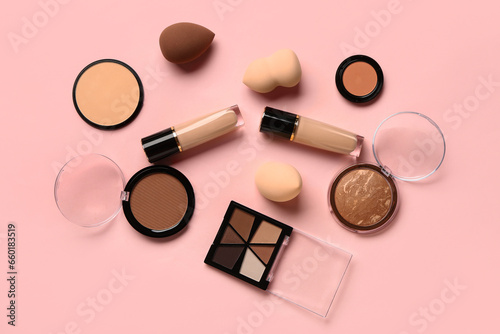 Composition with decorative cosmetics and makeup sponges on pink background