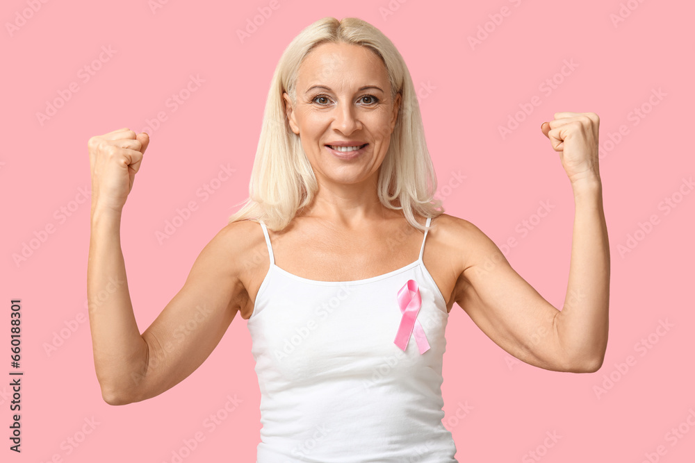 Happy mature woman with ribbon on pink background. Breast cancer awareness concept Happy mature woman with ribbon on pink background. Breast cancer awareness concept
