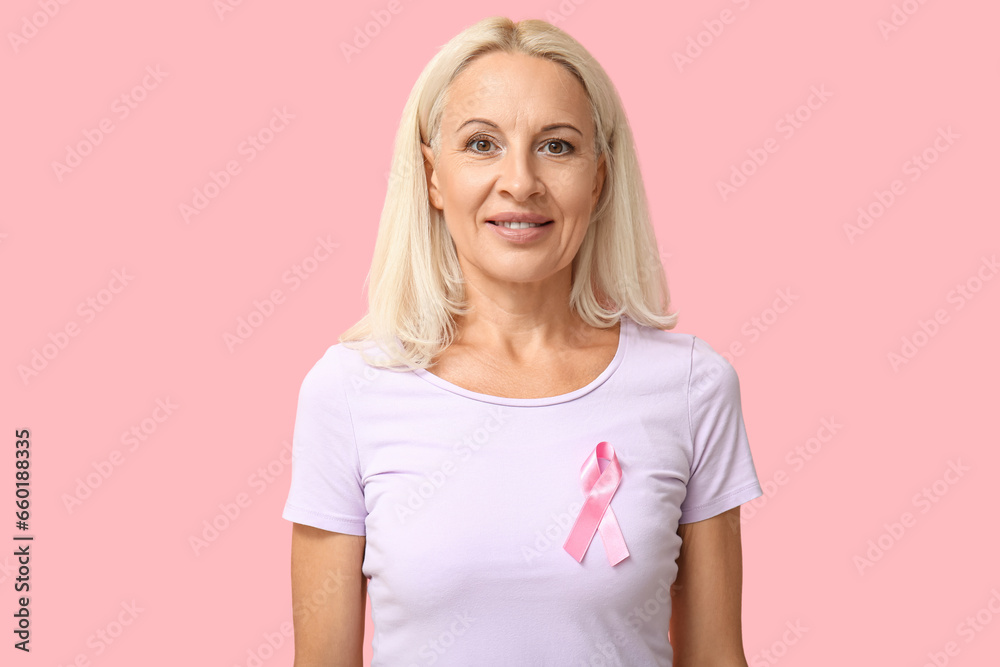 Mature woman with ribbon on pink background. Breast cancer awareness concept Mature woman with ribbon on pink background. Breast cancer awareness concept