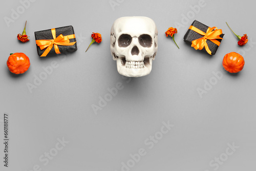Dia de los muertos celebration, human skull with marigold flowers and gift boxes for mexican day of the dead holiday tradition on gray background