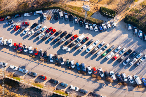 bird's-eye view of car rows at crowded parking lot.