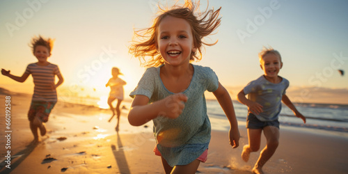 Fototapeta Naklejka Na Ścianę i Meble -  Closeup of kids running in the sand and shallow sea on a sunset / sunrise beach paradise — Joyful, happy, cinematic photography of children