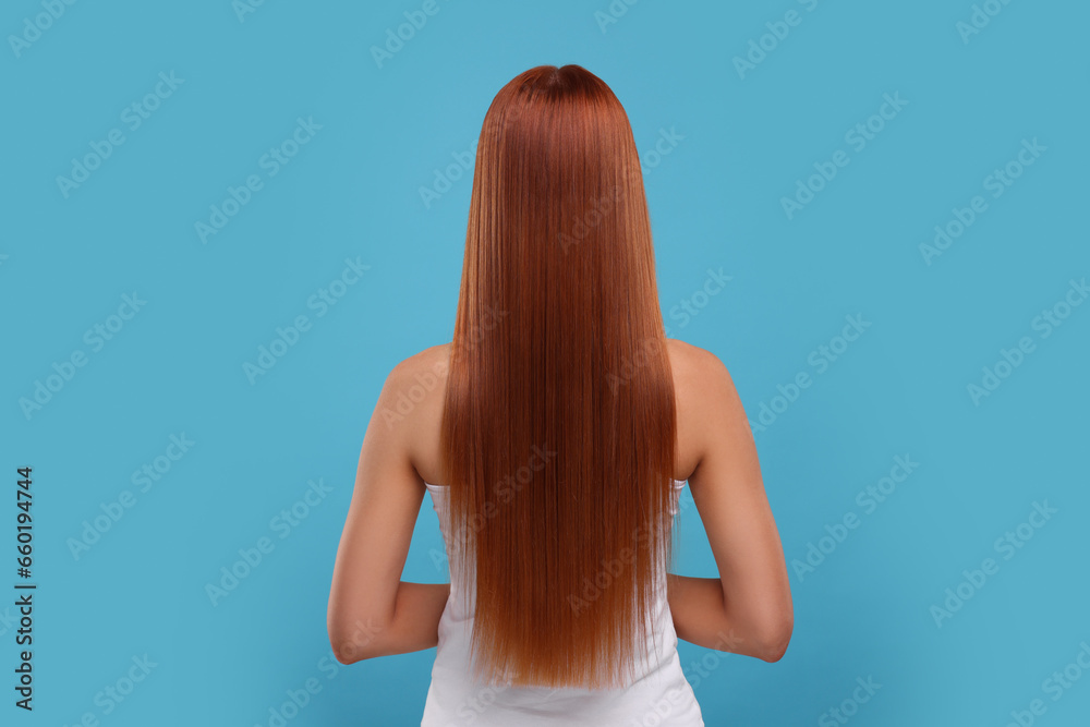 Naklejka premium Woman with healthy hair after treatment on light blue background, back view