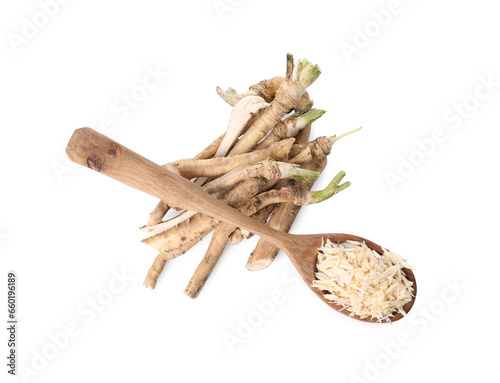Spoon with grated horseradish and roots isolated on white, top view