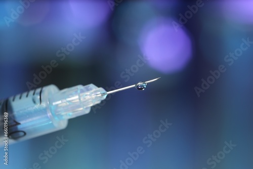 Syringe with medicine against blurred background, closeup. Space for text