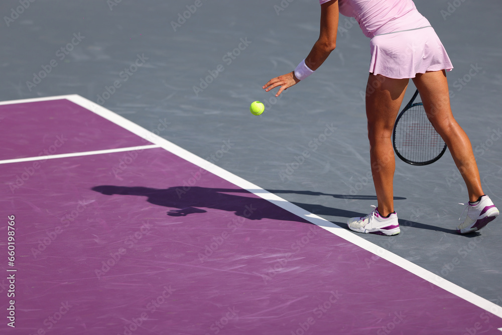 Female tennis player in action on the court on a sunny day, preparing to serve Female tennis player in action on the court on a sunny day, preparing to serve