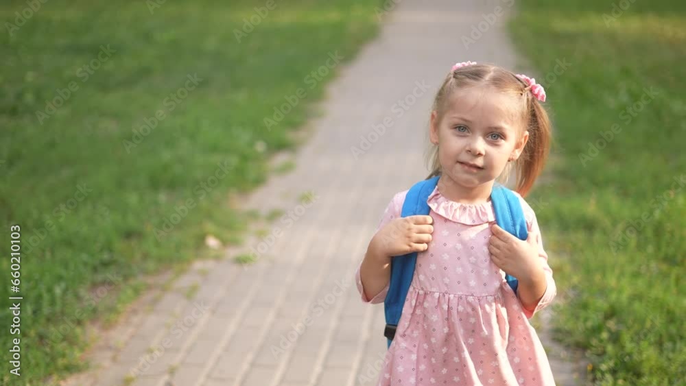 back to school. a child schoolgirl walk with a backpack to school in the park along the path. school education learning concept lifestyle. daughter child view from the back in backpack walk in park back to school. a child schoolgirl walk with a backpack to school in the park along the path. school education learning concept lifestyle. daughter child view from the back in backpack walk in park