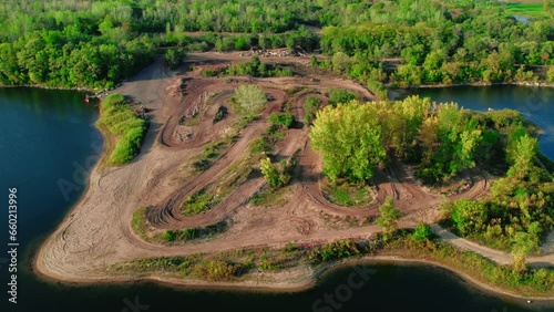 amazing aerial off road dirt bike motocross tracks next to a lake and forest. Sorounded by calm water and green foliage. Recreational riding place fot atv and motorcycles. Dirt bike enthusiasts photo