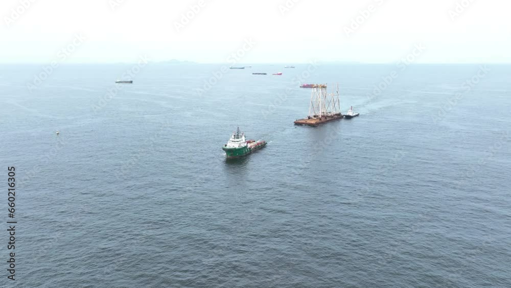 Tugboat pull Big Construction on ship. Tender Drilling Oil Rig on Barge Ship transportation Rid to Oil Rig in The Middle of The Ocean Tugboat pull Big Construction on ship. Tender Drilling Oil Rig on Barge Ship transportation Rid to Oil Rig in The Middle of The Ocean