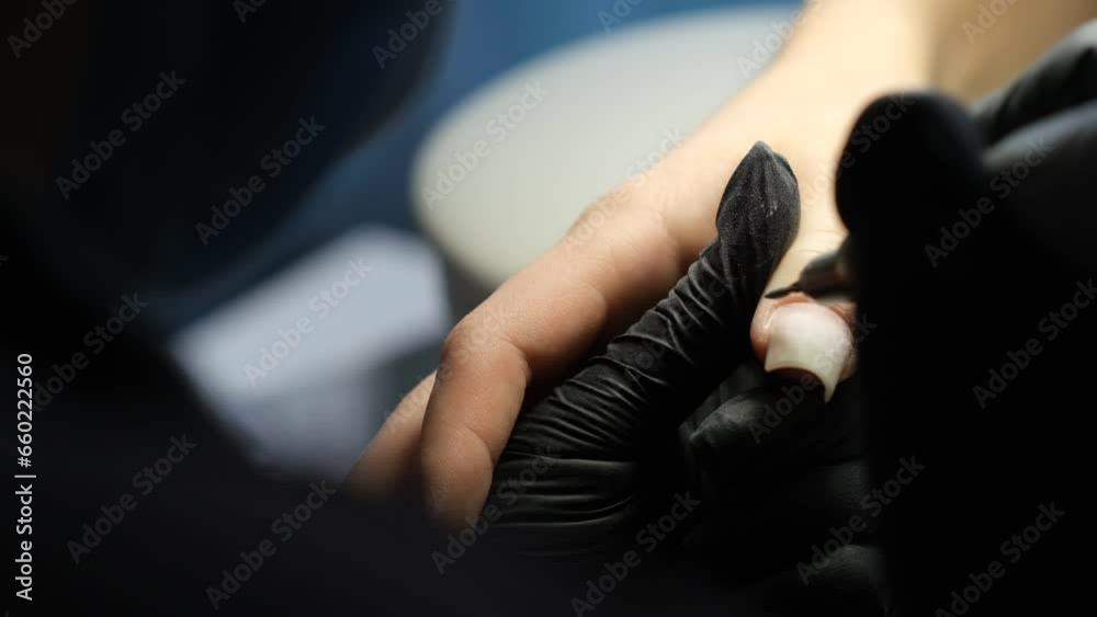 Female hands and tools for manicure, process of performing manicure in beauty salon. Nail care procedure in a beauty salon. Gloved hands of a skilled manicurist cutting cuticles. Concept spa body care Female hands and tools for manicure, process of performing manicure in beauty salon. Nail care procedure in a beauty salon. Gloved hands of a skilled manicurist cutting cuticles. Concept spa body care