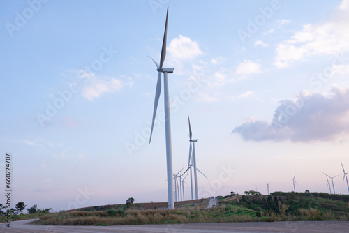 Windmill turbine farm for electricity generation on landscape mountain at sunset sky, Green power industry resouces, Sustainable and clean energy generator from wind and frieldly with enviroement photo