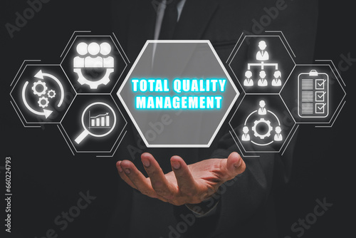 Total quality management concept, Businessman hand holding total quality management icon on virtual screen. photo