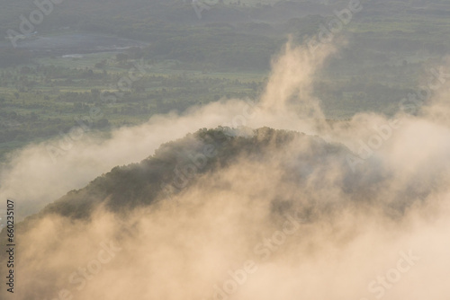 Morning foggy landscape. Fog and low clouds over the hills. Top view of clouds at sunrise. Beautiful aerial photo. Natural background.