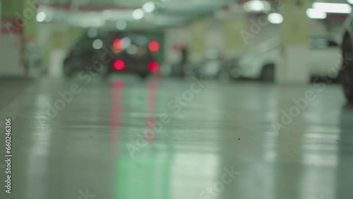 Modern city underground parking with blurred unrecognizable moving cars. Selective focus 4K photo