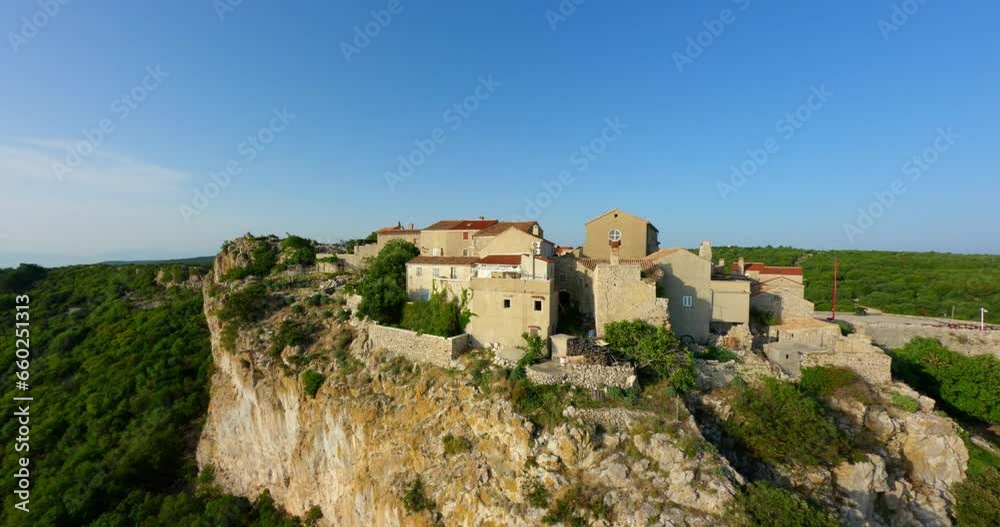 Sandstone wall and roofs of Lubenice village sits on cliff above Croatian coastline Sandstone wall and roofs of Lubenice village sits on cliff above Croatian coastline