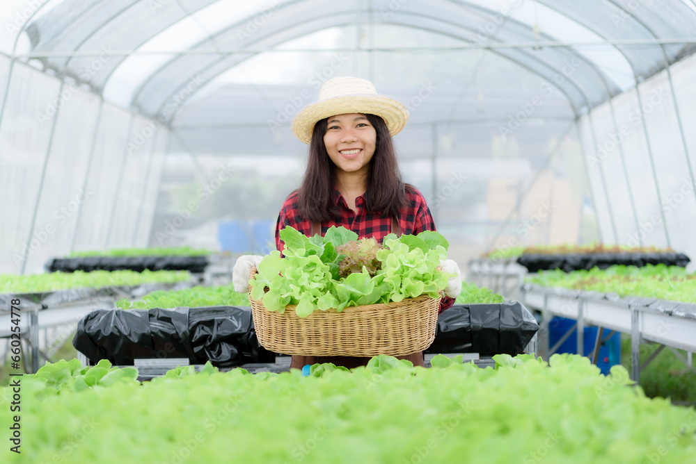 Asian female farmer holding vegetables showing to camera, smiling Modern business in the home building