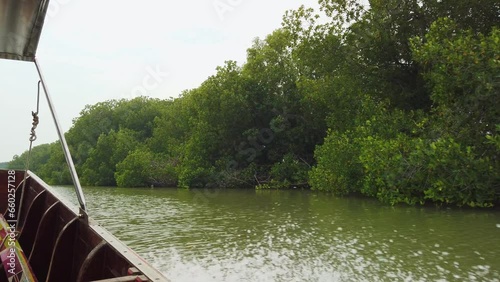 Take a traditional wooden long tail boat with beautiful scenery view of mangrove forest and local communities along the canal in Bangkok, Thailand, South East Asia. Board a traditional long tail boat.