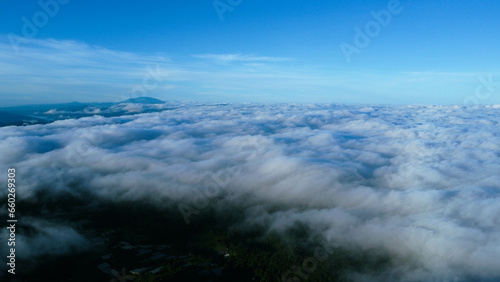 Aerial view over the mountains with sea of fog during morning sunrise in blue sky. Sea of clouds around mountain peaks at sunrise. Unseen travel in Northern Thailand