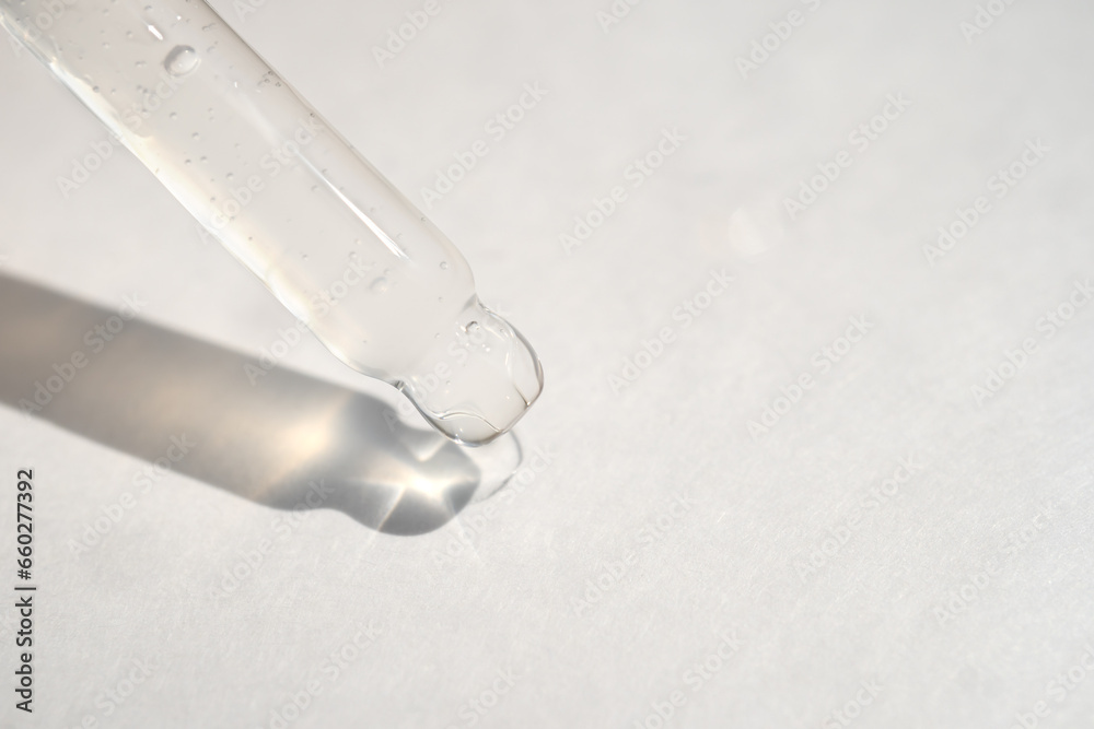 Naklejka premium Pipette with essential liquid serum or oil on white background