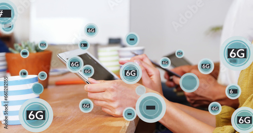 Image of 6g texts with symbols over caucasian coworkers using digital tablet