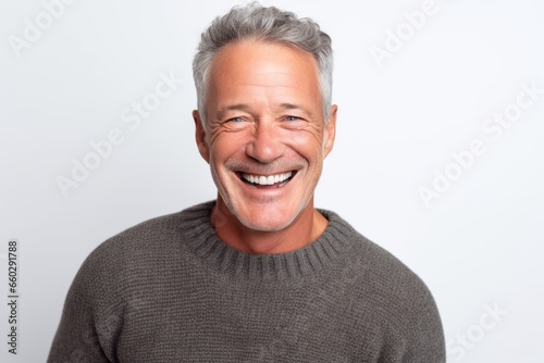 Portrait of happy senior man laughing and looking at camera against white background © igolaizola