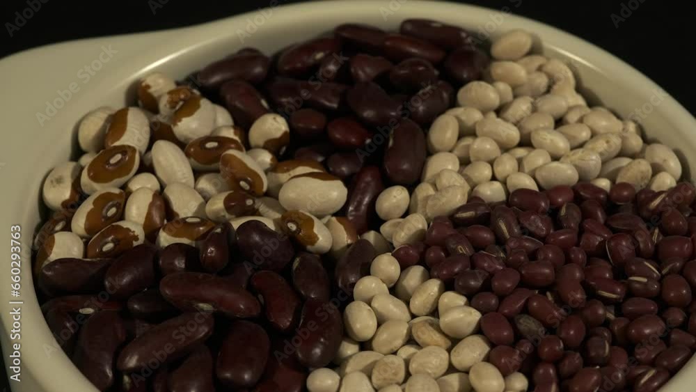 Spoke pattern dried beans in white bowl rotate in full frame close up Spoke pattern dried beans in white bowl rotate in full frame close up