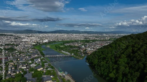 Aerial pull back away from Arashiyama, sunny summer day in downtown Kyoto, Japan photo