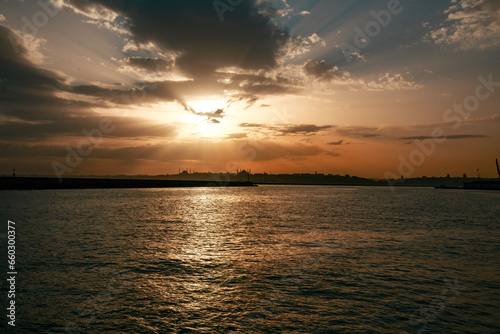 Calm view of the sunset gliding through the clouds over the calm sea