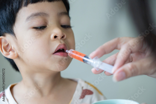 Canvas Print Baby toddler Asian child take an oral medical suspension an ibuprofen for reliev