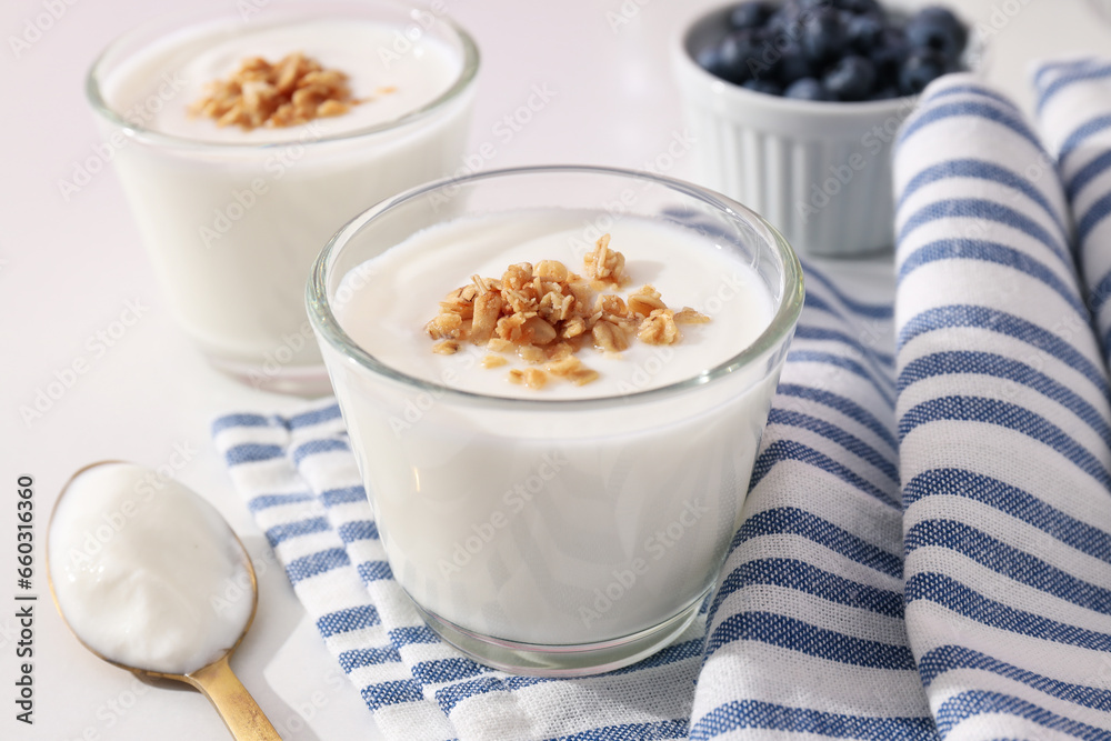 Bowls with yogurt and berries, spoon and towel on white background Bowls with yogurt and berries, spoon and towel on white background