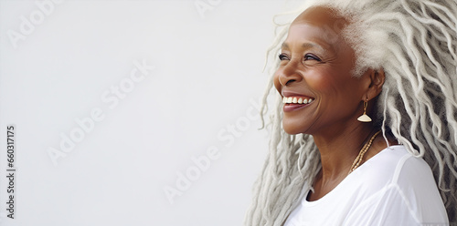  portrait of a beautiful elderly  black woman with long white hair, dressed white and light white background, posing and looking on camera photo