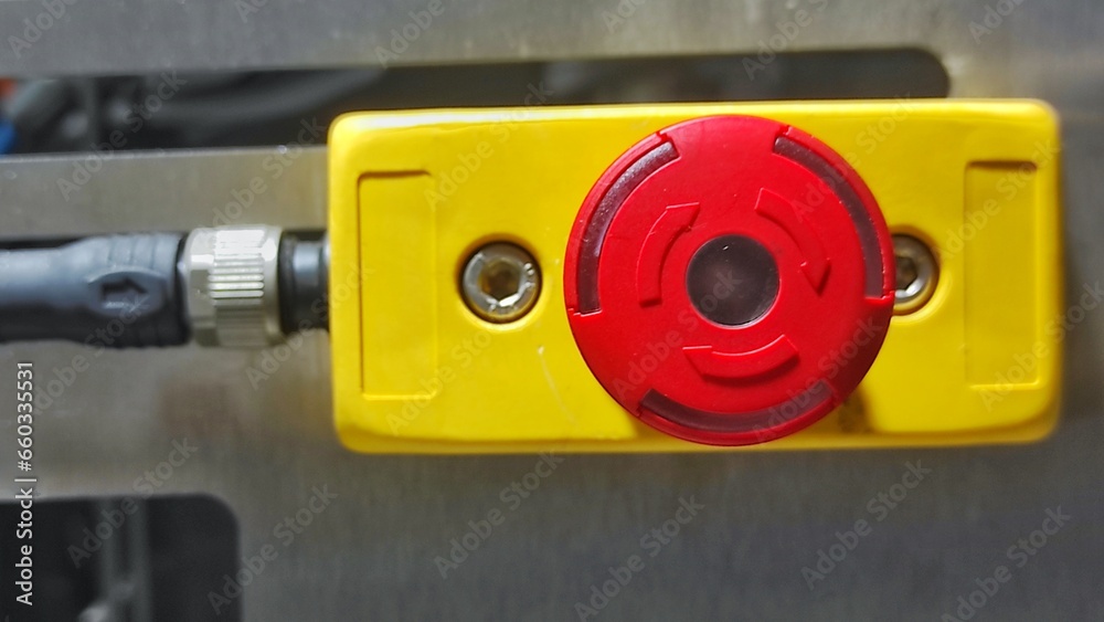 Red yellow emergency stop button on the machine in production room of factory 