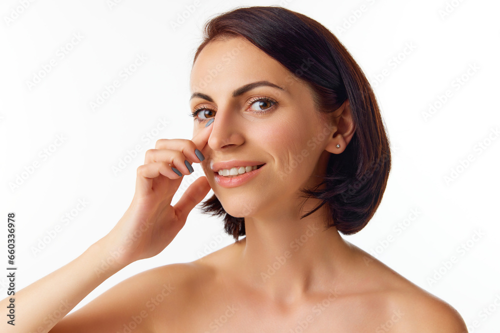 Pretty young short hair, brunette woman with naked shoulders touching her nose with finger. Rhinoplasty, plastic surgery concept Pretty young short hair, brunette woman with naked shoulders touching her nose with finger. Rhinoplasty, plastic surgery concept