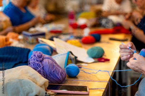 Crochet club. Ladies crocheting with colored wool. photo