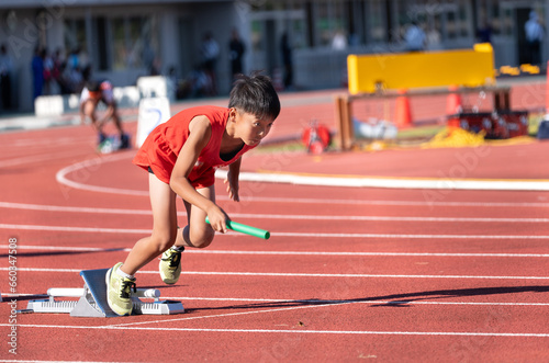 陸上大会でリレーを走る小学生の男の子 photo