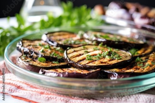 grilled smokey eggplant half placed on a glass dish