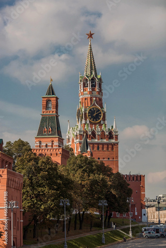 MOSCOW, RUSSIA - SEPTEMBER 26, 2023: The Kremlin's Spasskaya Tower on Red Square on a sunny autumn evening against a bright blue sky. A large clock and chimes on the Spasskaya Tower.