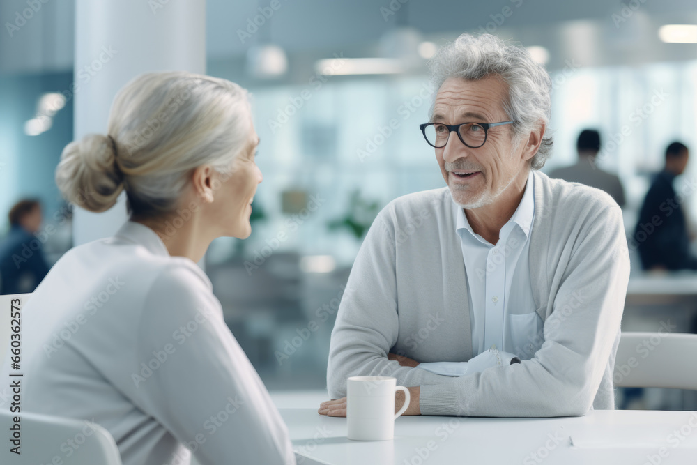Obraz premium Happy aged couple consulting with insurance agent, medical professional at home or office