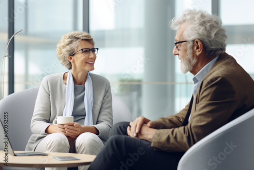 Happy aged couple consulting with insurance agent, medical professional at home or office photo