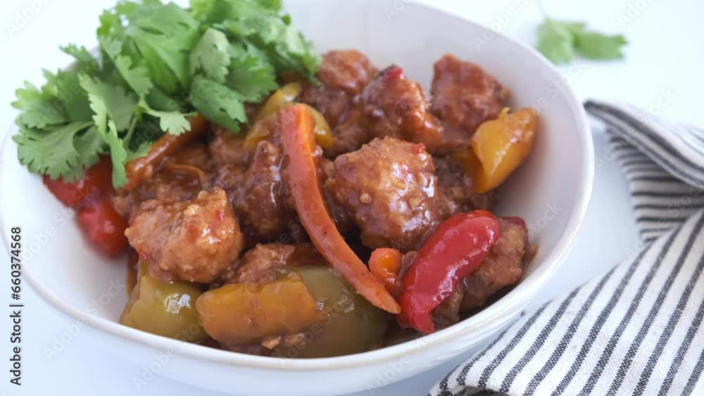 Stewed chicken fillet pieces with vegetables in white bowl with cilantro. Stewed chicken fillet pieces with vegetables in white bowl with cilantro.