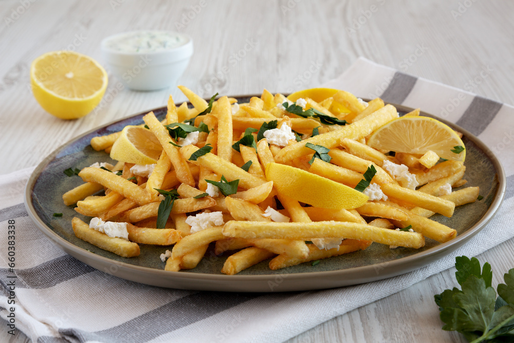 Homemade Greek Fries with Feta and Tzatziki on a Plate, side view.