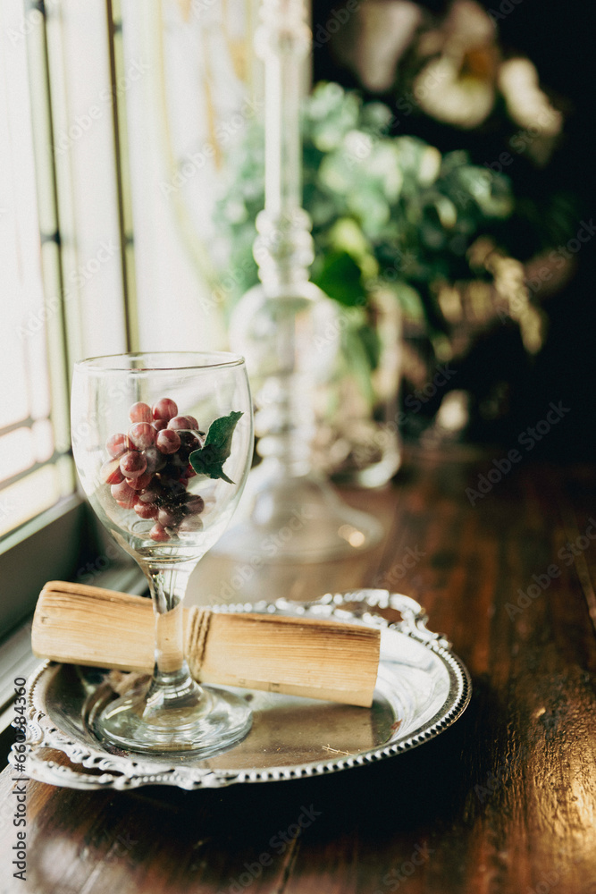 grape in wine glass with vintage roll of paper on Table. festive dinner setting with flowers. glassware and cutlery in a restaurant for a joyful celebration
