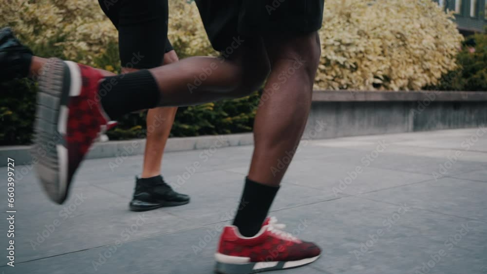 Sportive legs of woman and man running through city street Sportive legs of woman and man running through city street
