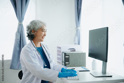 Mature Asian smiling doctor or consultant sitting at a desk his neck